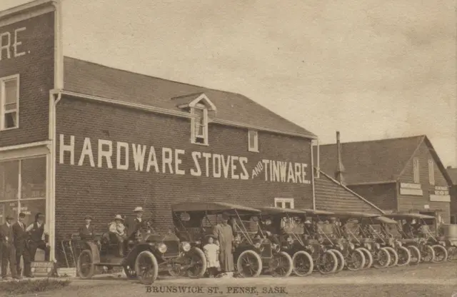Brunswick Street with row of automobiles outside the hardware store